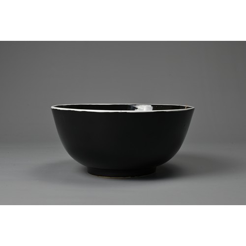 61 - A LARGE CHINESE BLACK GLAZED PORCELAIN BOWL, 20TH CENTURY. Heavily potted round bowl covered in a bl... 