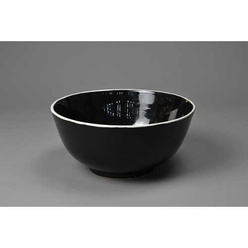 61 - A LARGE CHINESE BLACK GLAZED PORCELAIN BOWL, 20TH CENTURY. Heavily potted round bowl covered in a bl... 