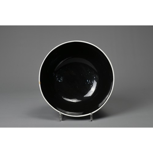 61 - A LARGE CHINESE BLACK GLAZED PORCELAIN BOWL, 20TH CENTURY. Heavily potted round bowl covered in a bl... 