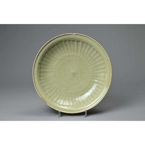 68 - A CHINESE LONGQUAN CELADON SHALLOW DISH. Fairly finely potted with moulded ribbed interior in the fo... 