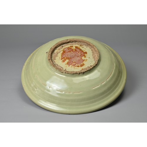 68 - A CHINESE LONGQUAN CELADON SHALLOW DISH. Fairly finely potted with moulded ribbed interior in the fo... 