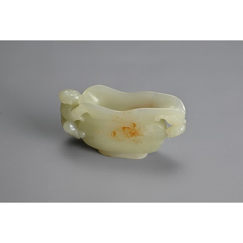 26 - A CHINESE CARVED PALE CELADON JADE CUP. Pale celadon colour with russet patches, featuring a boy han... 