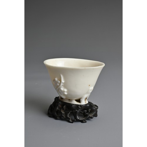 34 - A CHINESE BLANC DE CHINESE PORCELAIN LIBATION CUP, 17TH CENTURY. With applied floral sprays on an op... 