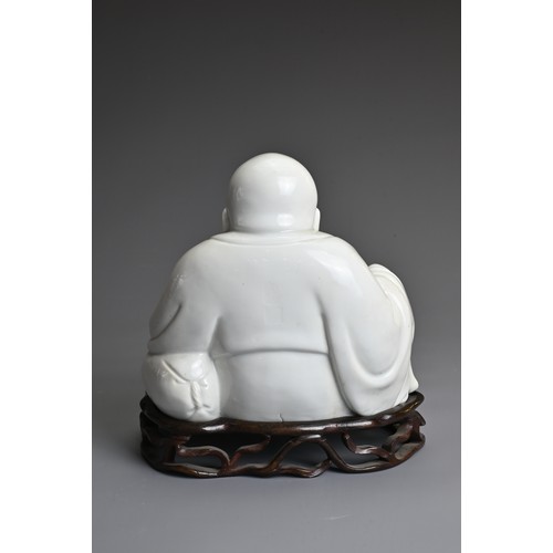 35 - A CHINESE BLANC DE CHINE FIGURE OF BUDAI, QING DYNASTY. The figure seated dressed in robes open at t... 