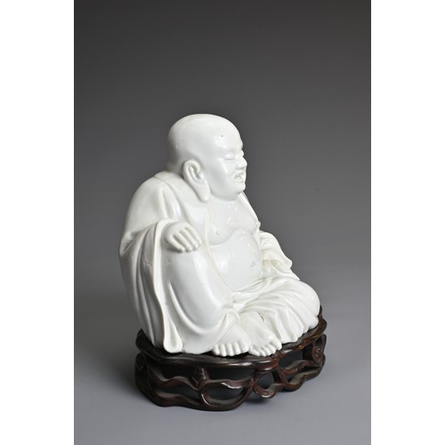 35 - A CHINESE BLANC DE CHINE FIGURE OF BUDAI, QING DYNASTY. The figure seated dressed in robes open at t... 