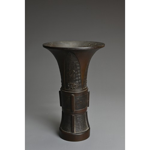 47 - A CHINESE BRONZE GU SHAPED VASE, QING DYNASTY. Archaic decoration with Taotie masks and flanges to t... 