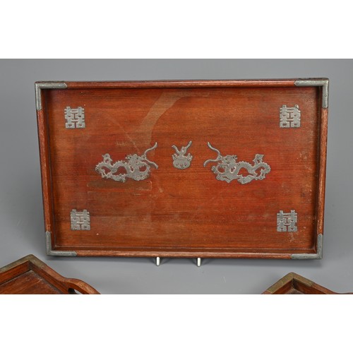 56 - THREE CHINESE WOOD TRAYS, EARLY 20TH CENTURY. To include a rectangular tray with metal dragons and x... 