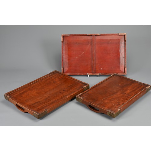 56 - THREE CHINESE WOOD TRAYS, EARLY 20TH CENTURY. To include a rectangular tray with metal dragons and x... 