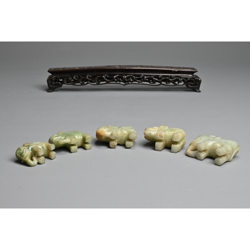 51 - CHINESE JADE ELEPHANT GROUP ON WOODEN STAND, 19/20TH CENTURY. A procession of five individually carv... 