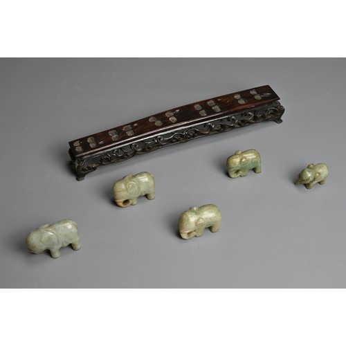 51 - CHINESE JADE ELEPHANT GROUP ON WOODEN STAND, 19/20TH CENTURY. A procession of five individually carv... 