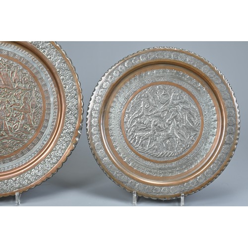 304 - TWO MIDDLE EASTERN TINNED COPPER DISHES, 20TH CENTURY. The first decorated in low relief with deer i... 