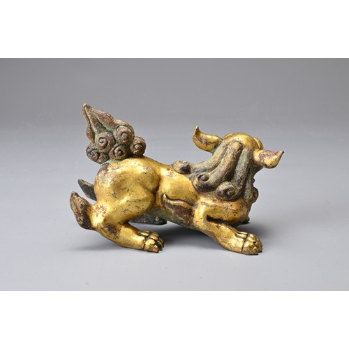 181 - A CHINESE GILT BRONZE FIGURE OF A LION, MING DYNASTY STYLE. In a playful position with its head turn... 