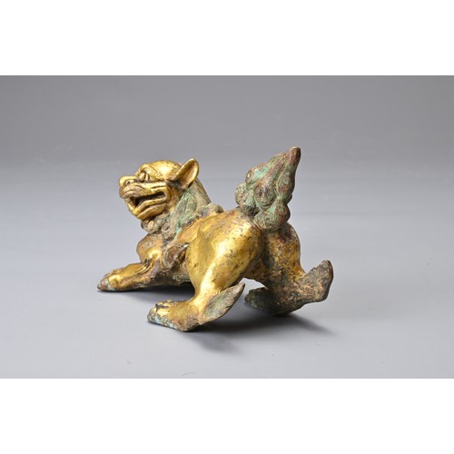 181 - A CHINESE GILT BRONZE FIGURE OF A LION, MING DYNASTY STYLE. In a playful position with its head turn... 