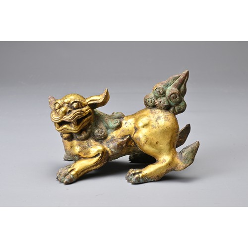 181 - A CHINESE GILT BRONZE FIGURE OF A LION, MING DYNASTY STYLE. In a playful position with its head turn... 