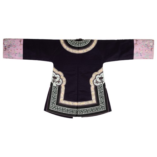 55 - TWO CHINESE EMBROIDERED SILK ROBES, CIRCA 1920 AND LATER. The first, early 20th century, in dark pur... 