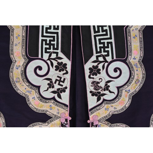 55 - TWO CHINESE EMBROIDERED SILK ROBES, CIRCA 1920 AND LATER. The first, early 20th century, in dark pur... 