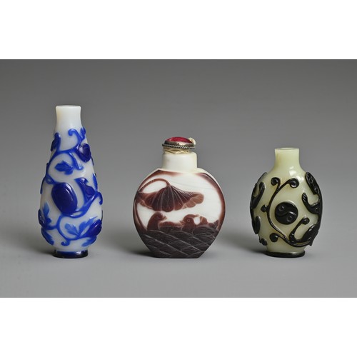 6 - THREE CHINESE GLASS OVERLAY SNUFF BOTTLES. To include  a black overlay bottle with chilong and yin y... 