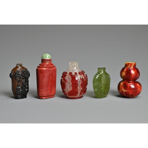 8 - A GROUP OF FIVE CHINESE GLASS SNUFF BOTTLES. To include a red overlay clear glass bottle with treasu... 