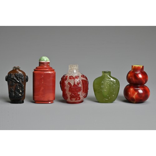 8 - A GROUP OF FIVE CHINESE GLASS SNUFF BOTTLES. To include a red overlay clear glass bottle with treasu... 