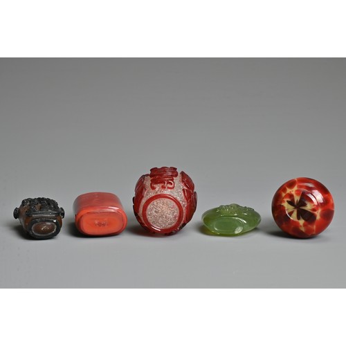 8 - A GROUP OF FIVE CHINESE GLASS SNUFF BOTTLES. To include a red overlay clear glass bottle with treasu... 