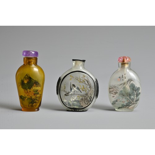 14 - THREE CHINESE GLASS SNUFF BOTTLES. To include an inside painted bottle with black overlay, decorated... 