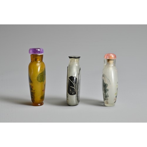 14 - THREE CHINESE GLASS SNUFF BOTTLES. To include an inside painted bottle with black overlay, decorated... 