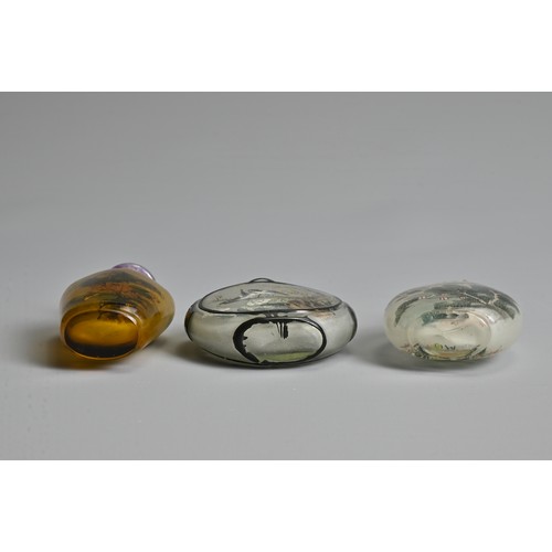 14 - THREE CHINESE GLASS SNUFF BOTTLES. To include an inside painted bottle with black overlay, decorated... 