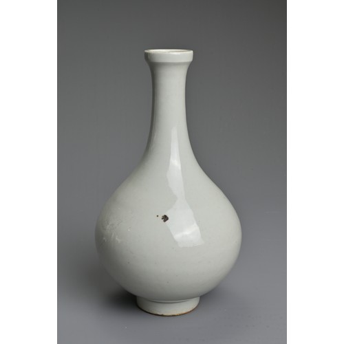 83 - A CHINESE WHITE GLAZED BOTTLE VASE. Of pear shape on raised foot incised with figure of a dragon. Wi... 