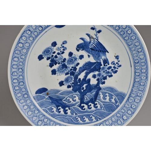 56 - A CHINESE BLUE AND WHITE PORCELAIN DISH, 19TH CENTURY. Decorated with an eagle and flowers on rockwo... 