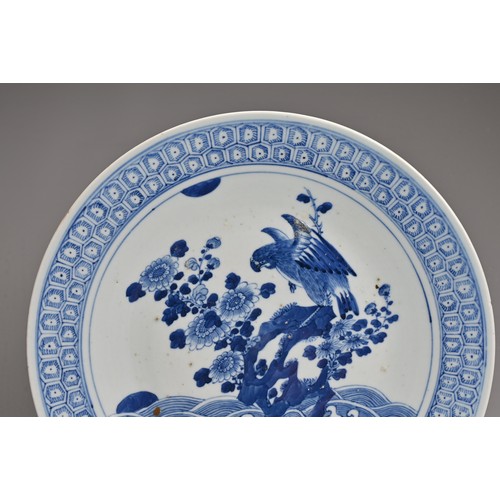 56 - A CHINESE BLUE AND WHITE PORCELAIN DISH, 19TH CENTURY. Decorated with an eagle and flowers on rockwo... 