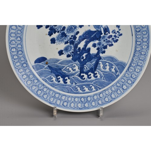 56 - A CHINESE BLUE AND WHITE PORCELAIN DISH, 19TH CENTURY. Decorated with an eagle and flowers on rockwo... 