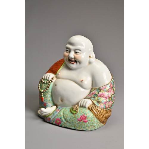 229 - A CHINESE FAMILLE ROSE PORCELAIN FIGURE OF BUDAI, MID 20TH CENTURY. The laughing Buddha seated dress... 