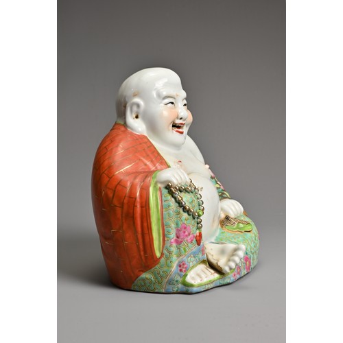 229 - A CHINESE FAMILLE ROSE PORCELAIN FIGURE OF BUDAI, MID 20TH CENTURY. The laughing Buddha seated dress... 