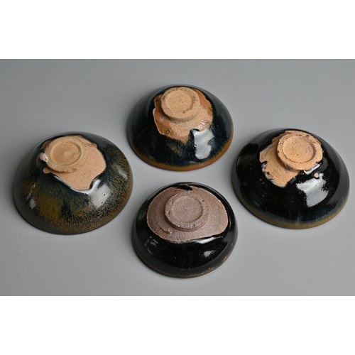 123 - FOUR CHINESE BLACK GLAZED POTTERY TEA BOWLS. Of varying sizes to include a hare's fur glazed bowl wi... 