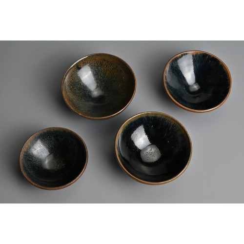 123 - FOUR CHINESE BLACK GLAZED POTTERY TEA BOWLS. Of varying sizes to include a hare's fur glazed bowl wi... 