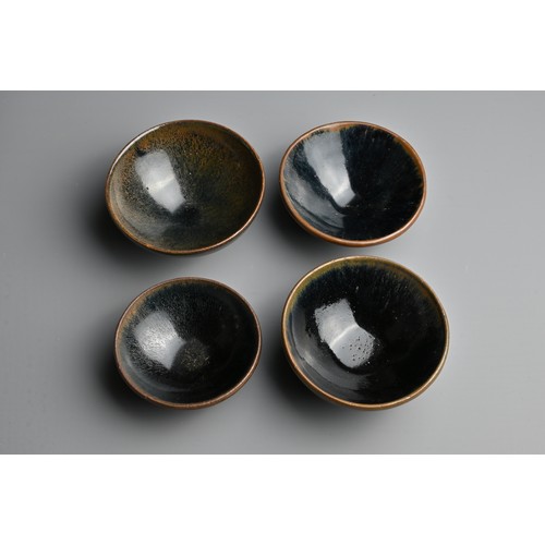 123 - FOUR CHINESE BLACK GLAZED POTTERY TEA BOWLS. Of varying sizes to include a hare's fur glazed bowl wi... 