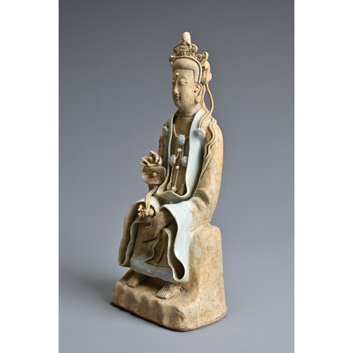 118 - A CHINESE SONG DYNASTY STYLE FIGURE OF GUANYIN, with qingbai glaze, in seated position holding a lot... 