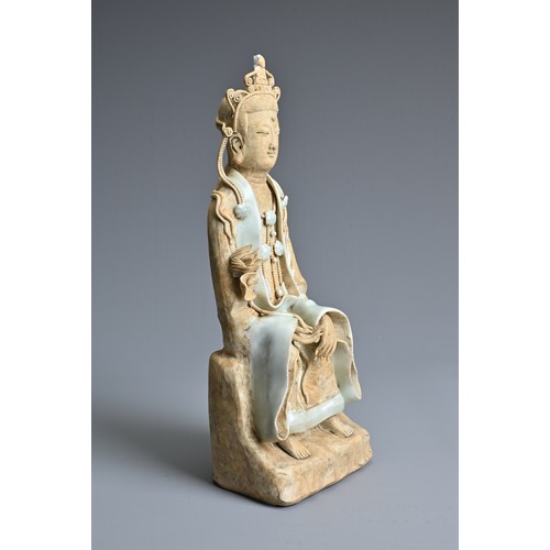 118 - A CHINESE SONG DYNASTY STYLE FIGURE OF GUANYIN, with qingbai glaze, in seated position holding a lot... 