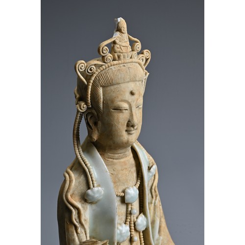 118 - A CHINESE SONG DYNASTY STYLE FIGURE OF GUANYIN, with qingbai glaze, in seated position holding a lot... 