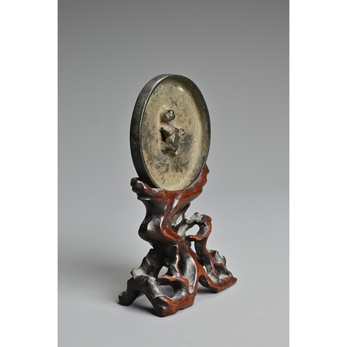 163 - A CHINESE BRONZE MIRROR ON WOODEN STAND, TANG DYNASTY (618–907). Circular form with animal form fini... 