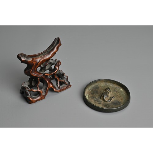 163 - A CHINESE BRONZE MIRROR ON WOODEN STAND, TANG DYNASTY (618–907). Circular form with animal form fini... 