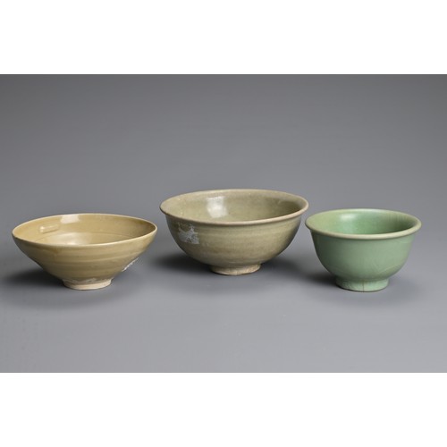 159 - THREE CHINESE CELADON GLAZED BOWLS, SONG TO MING DYNASTY. Each of varying designs covered in a celad... 