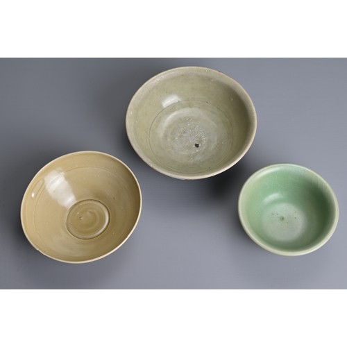 159 - THREE CHINESE CELADON GLAZED BOWLS, SONG TO MING DYNASTY. Each of varying designs covered in a celad... 