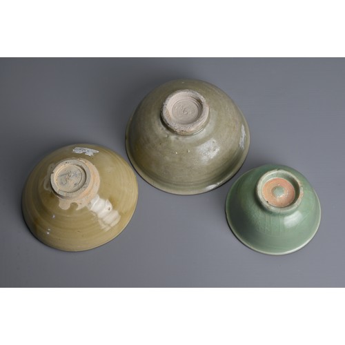 159 - THREE CHINESE CELADON GLAZED BOWLS, SONG TO MING DYNASTY. Each of varying designs covered in a celad... 