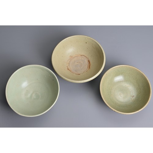 144 - THREE CHINESE CELADON GLAZED BOWLS, YUAN / MING DYNASTY. Each thickly potted with varying designs. 1... 