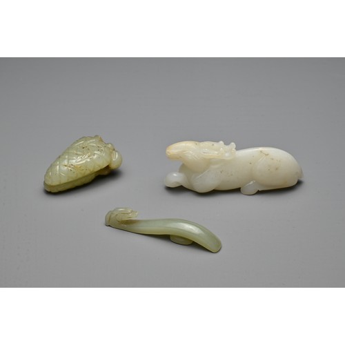 71 - THREE CHINESE CARVED JADE ITEMS. To include a white jade model of a recumbent deer; A small celadon ... 