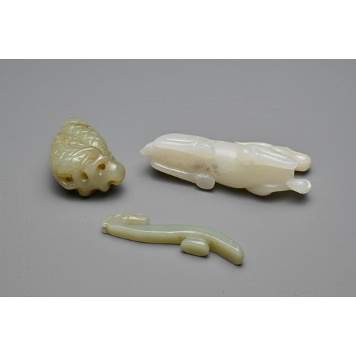 71 - THREE CHINESE CARVED JADE ITEMS. To include a white jade model of a recumbent deer; A small celadon ... 