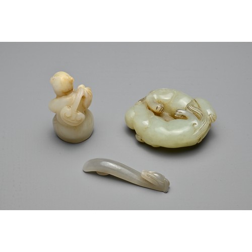 72 - THREE CHINESE CARVED JADE ITEMS. To include a celadon lion group; A small grey dragon head belt hook... 