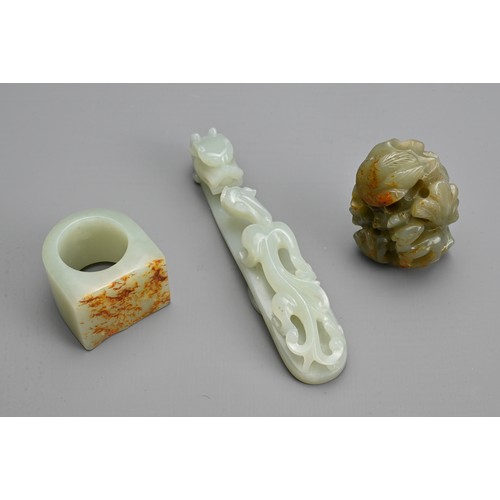 74 - THREE CHINESE CARVED JADE ITEMS. To include pale celadon openwork chilong and dragon head belt hook;... 