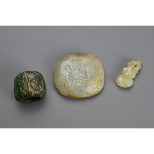 75 - THREE CHINESE CARVED JADE ITEMS. To include a celadon jade belt plaque carved in relief with figure ... 